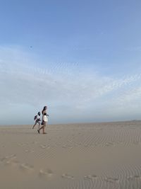 People on beach against sky