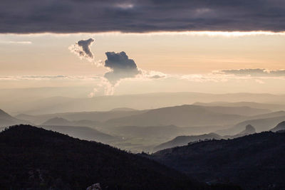 Scenic view of silhouette mountains against sky at sunset