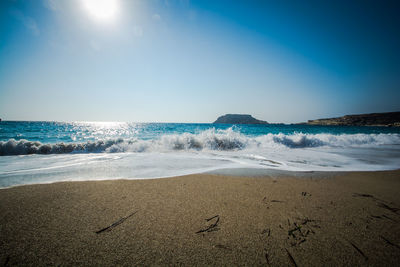 Scenic view of beach against blue sky