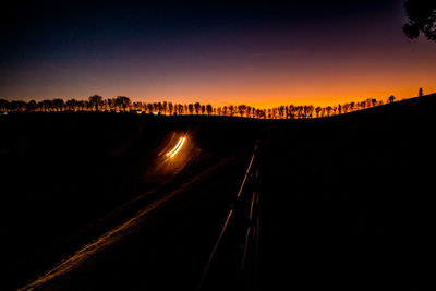 View of illuminated road against sky during sunset