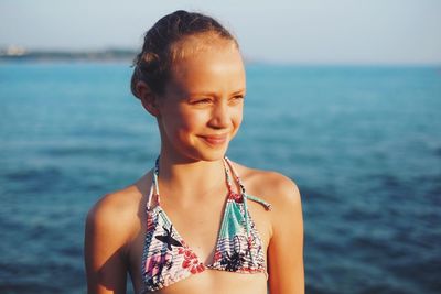 Cute smiling girl looking away at beach