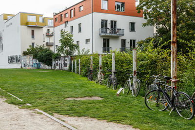 Bicycle by house on field against buildings