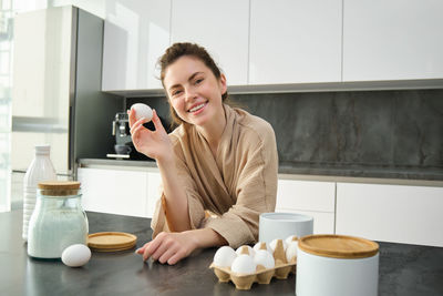 Portrait of young woman drinking coffee at home