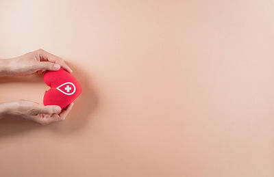 Close-up of woman hand against red wall