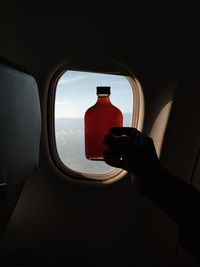 Close-up of hand holding glass window of car