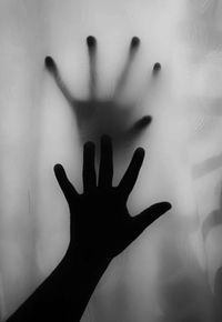Shadow of person hand on glass