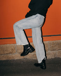 Low section of man standing against wall