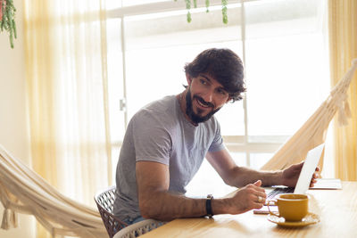 Young business man working at home in his kitchen with laptop. gray notebook. home office 