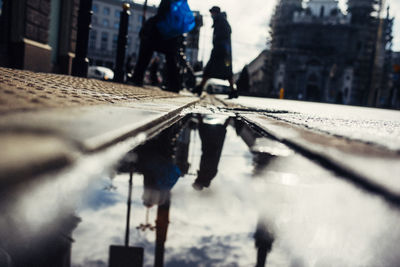 Low section of man standing on street by city