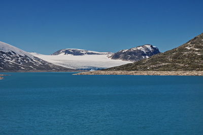 Scenic view of snowcapped mountains against clear blue sky