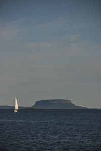 Sailboat sailing on sea against sky