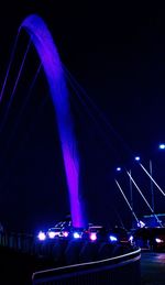 Low angle view of illuminated bridge against blue sky