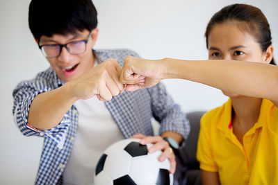 Close-up of friends bumping fists at home