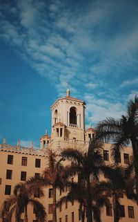 Low angle view of palm trees and buildings against sky