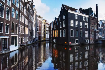 Canal amidst buildings against sky in city