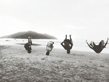 People on beach by sea against sky