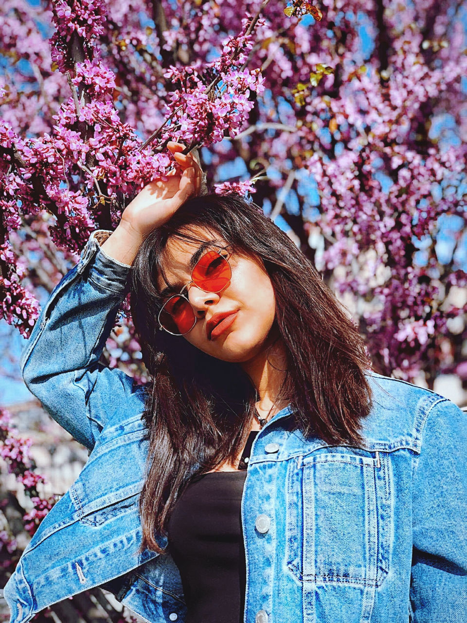 PORTRAIT OF BEAUTIFUL WOMAN WITH RED FLOWER IN MOUTH