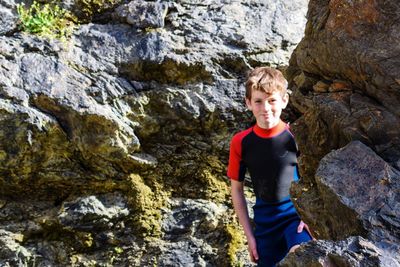 Portrait of boy standing by rock formations