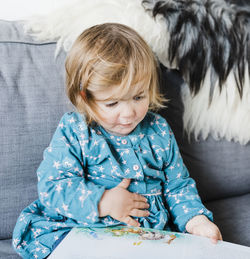 Cute girl reading book at home