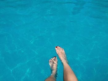 Low section of young woman in swimming pool during summer