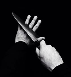 Close-up of hand holding over black background