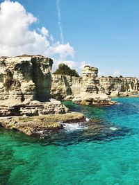 Panoramic view of cliff by sea against sky