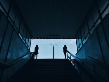 Low angle view of women standing on staircase