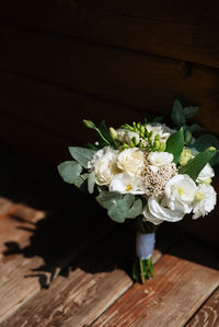 Midsection of woman with bouquet on table