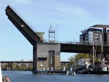 Bridge over river in city against sky