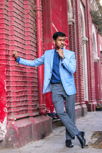 Full length of a young man with red umbrella