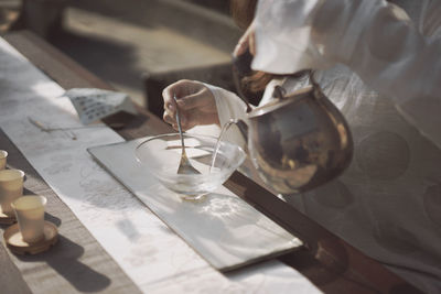 Midsection of woman pouring water in bowl