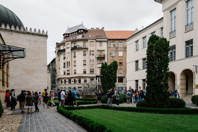 People on street in city against sky