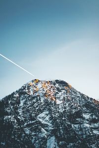 Low angle view of snow covered mountain against sky