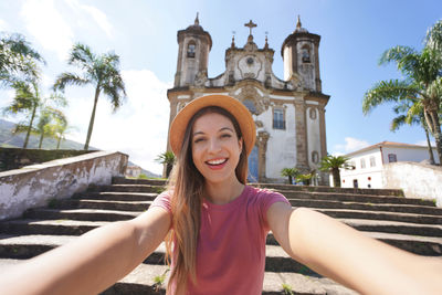 Woman takes self portrait in the colonial city of ouro preto, brazil, unesco world heritage site