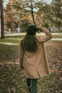 Rear view of woman walking in park during autumn