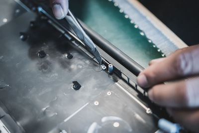 Cropped hands of technician repairing computer part