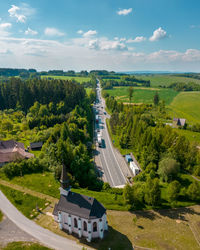 High angle view of road amidst trees against sky