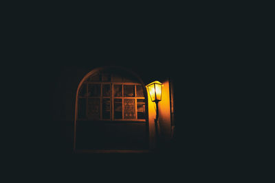 Illuminated lamp by building at night