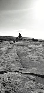 Father and son on land against sky