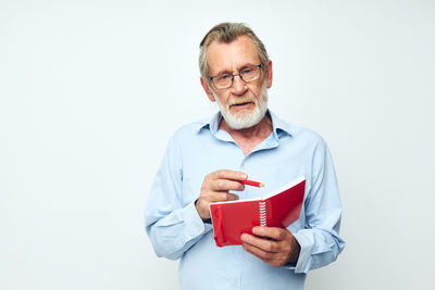 Portrait of young man using mobile phone against white background