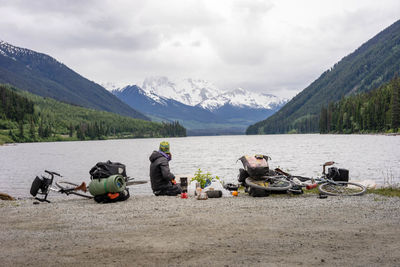 People relaxing in lake against mountains