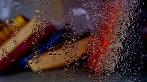 Books seen through wet glass window