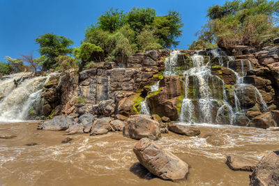 Scenic view of waterfall against sky