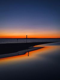 Scenic view of sea against orange sky