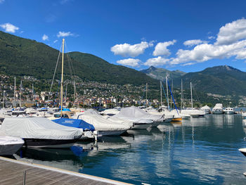 Sailboats moored in sea against sky