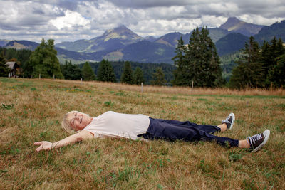 Full length of woman lying on grassy field