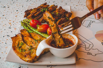 Close-up of person eating food on table