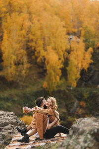 Happy people in love are travel hike in nature in the autumn forest. romantic trip to countryside