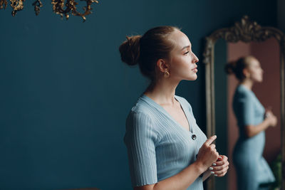 Side view of young woman looking at camera