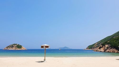 Scenic view of beach against clear blue sky